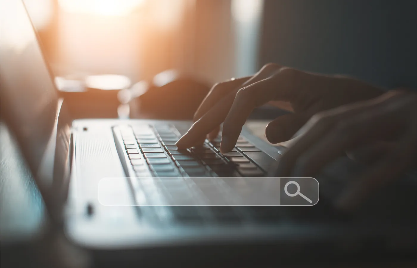 Hands typing on a laptop with a search bar overlay
